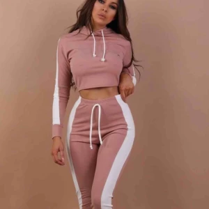  - Helt nytt jättefint set! Rosa med vita detaljer. Croppad tröja med långa byxor.  Strl M  Köparen betalar frakten!