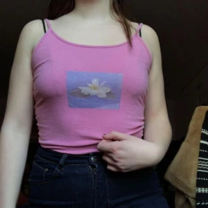  - Säljer detta rosa linnet med en blå ruta på med en näckros på! Unikt och gulligt linne som jag köpt på humana 