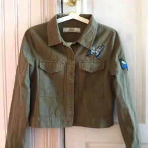  - Snygg militärgrön jacka med fjärilsstickers. 🦋🐍 snygg passform. Perfekt längd och rak, modern passform. Säljs pga att jag har en till liknande jacka ☺️ PERFEKT TILL VÅR