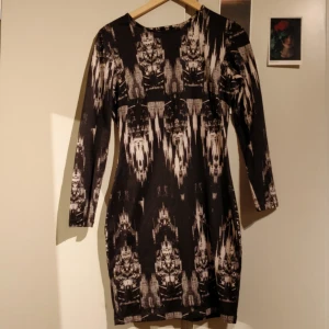  - Sexig klänning av stretch material. Kort klänning med långa ärmar och snygg skärning i ryggen. Supersnyggt mönster och mjukt tyg. En gammal favorit som tyvärr blivit för liten. Perfekt för utgångar i vår och sommar!