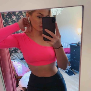  - Neonrosa croppad tröja med endast en arm, oanvänd så i bra skick. Säljs p.g.a. Att den inte kommer till användning. Köparen står för frakt 