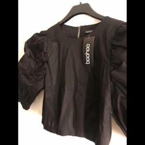 Fest topp från boohoo - En riktigt snygg topp med puff armar som tyvärr var för liten för mig när jag fick hem den. Aldrig använd. Ej stretchigt material. Knapparna ute i armarna går att knäppa. Dragkedjan är riktig✨