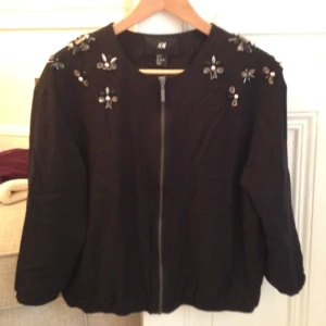  - Snygg festlig jacka/tröja från HM med paljettbrodyr. Färg: Svart. I gott skick, säljs som obehövlig. 
