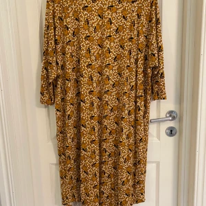 Monki - Monki klänning. Gul men kvinnor och blommor. Jätteskön modell. 