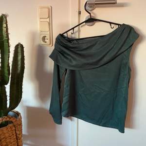 One shoulder satin blouse i färgen grön från en av Hannalicious kollektioner med NA-KD. Strl 34. OBS!!! Fraktkostnad kan ändras vid köp av plagg (beroende på ifall en större påse behövs)