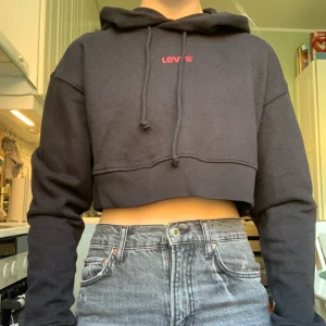 Levi’s Hoodie - Trendig kort hoodie storlek XS, passar dock även S och M.Trendig och köpt i New York för $69. Aldrig använd, prislappar kvar! BUDA🤪