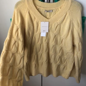 Kabelstickad gul tröja - Säljer denna fina gula kabelstickade tröja från Ginatricot då den tyvärr aldrig kom till användning. Den är en oversized tröja i strl XS men funkar bra på en S också. Prislappen finns kvar.