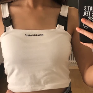 Vitt linne med text - Snyggt linne med spännen från Tally Weijl! Använt mycket få gånger. Verkligen en snygg topp, men den är inte riktigt min stil längre. Fri från fläckar och skador så den är i ett nytt skick. Frakt tillkommer😊💞