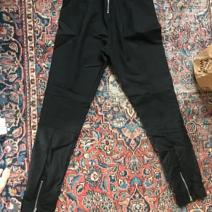 Tiger kostymbyxor  - Svarta snygga kostymbyxor från Tiger. Fint skick. Nypris 1300kr. Baksidan har dragkedjor vid anklarna och svanken. 