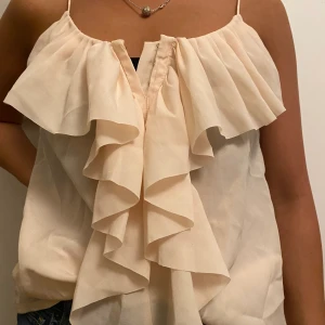 Ljusrosa blus - Volanger framtill