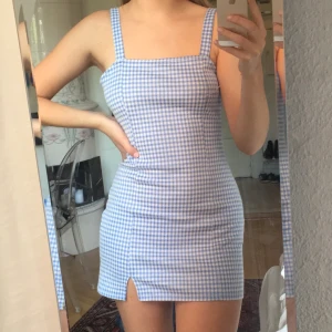 Rutig mini-klänning - Supersöt rutig klänning fr Bershka i vitt och blått. I princip oanvänd pga väldigt kort på mig som är 175cm. Strl M, men upplever den mkt mer som en S längsmässigt - dock väldigt strechig i materialet så i övrigt allt från XS-M!