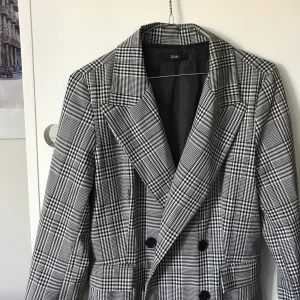 Rutig kappa - En tunn kappa som kanske passar bäst till våren, rutigt mönster och sidoknäppning. 