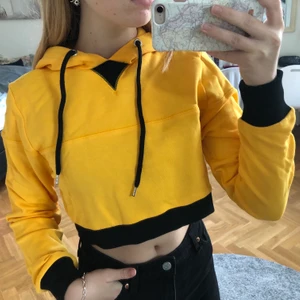 Gul/svart hoodie - En snygg gul och svart hoodie från nakd, ✨oanvänd✨ Den är croppad, 80kr🌟