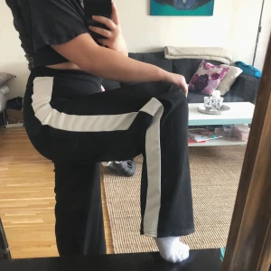  - Vida byxor med vit rand längs båda benen, aldrig använda!