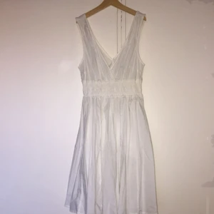  - V-ringad vit bomullsklänning från H&M. Strl 36. Klänningen är mycket fin på och passar både fest och vardag.
