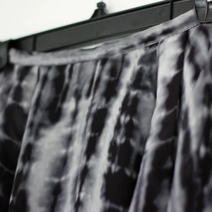  - Mönstrad kjol i polyester från H&M Divided i storlek 34, dock relativt smal midja, snarare storlek 32 där. Dragkedja baktill. Volang framtill. Längre baktill. Inner-/underkjol.  Kan mötas upp i Göteborg eller fraktar mot betalning.