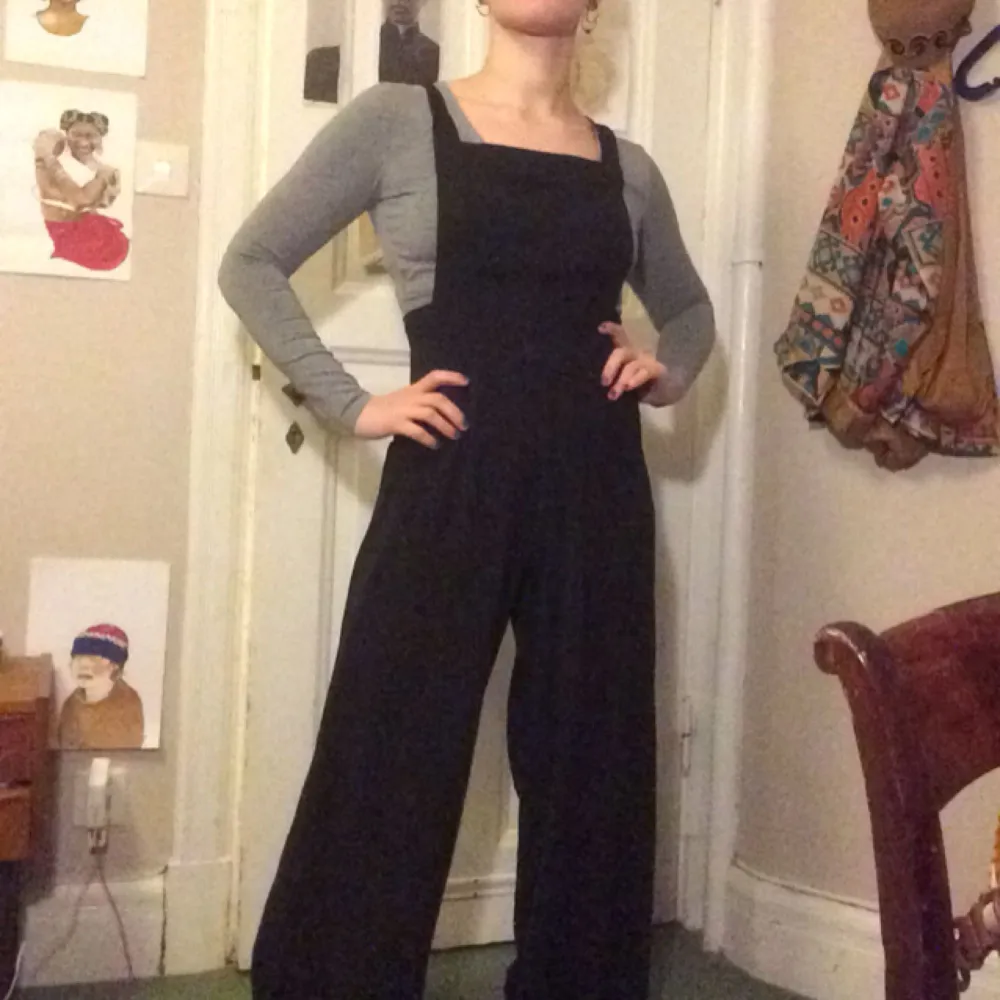 Full lenght black jumpsuit, wide legs with a lovely flowy fabric and a back with straps that you can change to be straight or crossed! +50kr frakt. Kostymer.