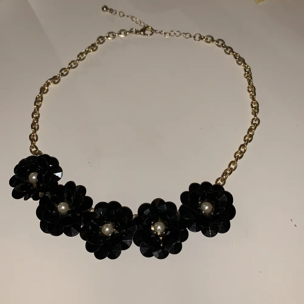 Ett fint halsband i guldfärg och med svarta blommor!. Accessoarer.