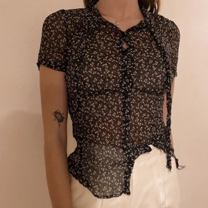 Tunn blus med knäppning  - Söt tunn blus med blommotiv. Snygg till ett par jeans och sneakers. Passar en XS-S. Bud från 75! 💖