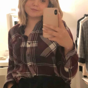  - Rutig skjorta med två fickor och man kan knäppa skjortan vid armarna. Jag har bara använt skjortan 2 gånger, kände att den inte kom till rätt användning. 