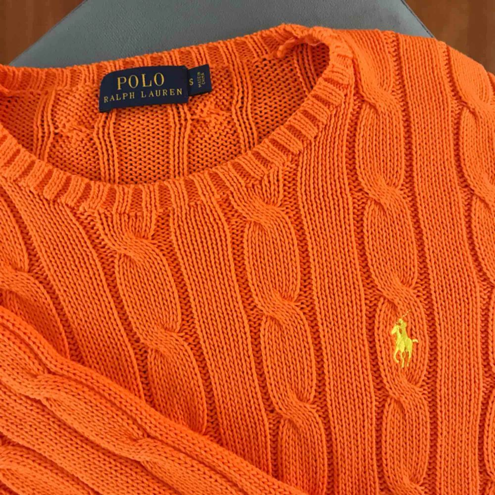 Klassisk, orange kabelstickad tröja från Ralph Lauren i bra skick. Använd ca 2 gånger. Jag möts upp i Stockholm eller köparen betalar frakten. Tar endast emot swish. . Stickat.