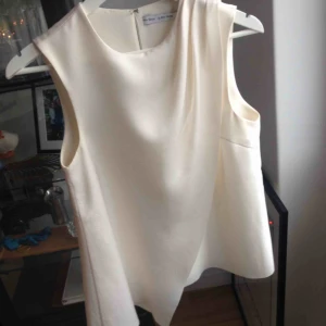  - Gräddvit blus från & other stories, storlek 36. Lite glänsande tyg i draperingen fram, något mattare tyg i övrigt. Använd 2-3 gånger. 