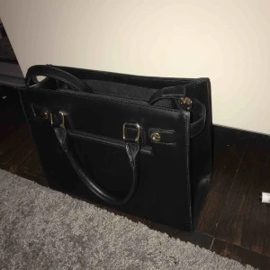  - Handväska med gulddetaljer, står inte vart den kommer ifrån.  Frakt står köparen för :)