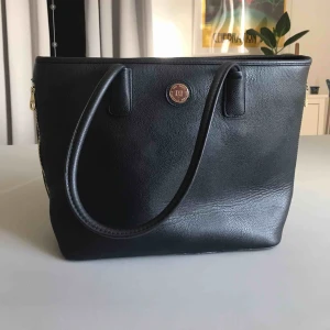  - En snygg väska i läderimitation. Använd som skolväska och är perfekt i storlek för mappar och dator. Trots att den är väl använd är den i väldigt fint skick. Små fläckar i innerfodret, kan ses på bild två. Köpt för 599kr.  (Köparen står för frakten) 