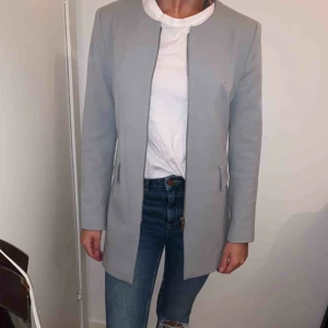  - Ljusgrå/ljusblå kappa i stilren skärning