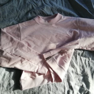  - Boxig collegetröja från Acne med stora ärmar och dragkedja i sidorna. 