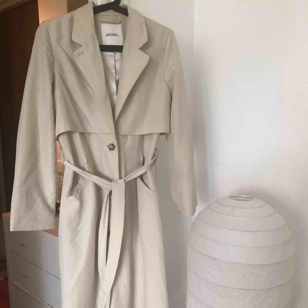 Ljusbeige kappa/trenchcoat ifrån Monki. Nypris låg runt 700-800! Kappan har nästan inte använts alls så den är i finfint skick! En liten fläck på kragen som säkert kan tvättas bort!. Jackor.