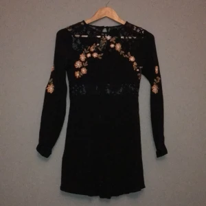 Forever21  - Svart kort figursydd klänning med spetsdetaljer i hals och midja. Köpt i New York på Forever21, sparsamt använd. Köpare står för frakt!