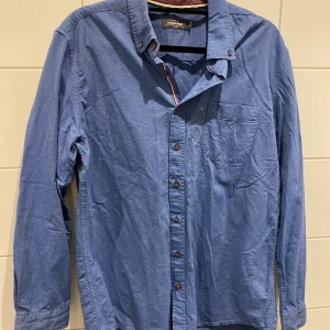 Dressmann skjorta XL - Märke: Dressmann Storlek: XL Modell: Slim Fit Färg: Blå Material: 100% Bomull  Nästan som nytt. I mycket bra skick, inga tecken på slitage! Frakt  55kr Samfraktar givetvis