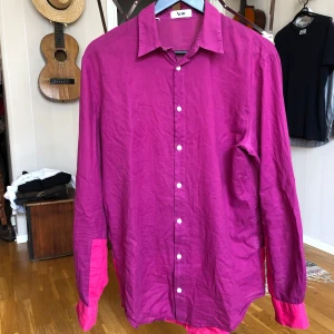 ACNE Skjorta lila/rosa i stl 50 - Skjorta från ACNE i lila med rosa inslag i storlek 50. Väldigt tunn och fin i materialet och passar perfekt till sommaren. Begagnad men i bra skick!