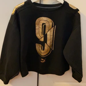 Puma tröja - Söker en svart puma tröja med fräcka guld detaljer
