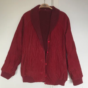 Manchesterjacka - Min älskade gamla röda manchesterjacka. Väl använd! - så lite sliten. Små hål i fickorna och en liten svart fläck, som ni ser på tredje bilden. Annars i gott skick, det är gediget finskt hantverk. Varm och go är den också!