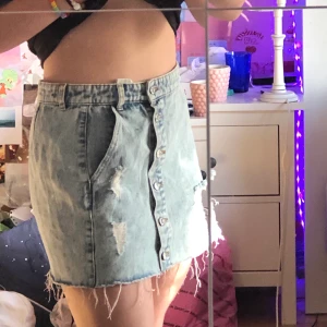 Jeans kjol med slitningar  - Kjol från pull and bear. Säljer pga att jag inte använder den, kjolen är i strl L men är väldigt liten i storleken. passar dock mig som har S i vanliga fall. Den är i ny skick 