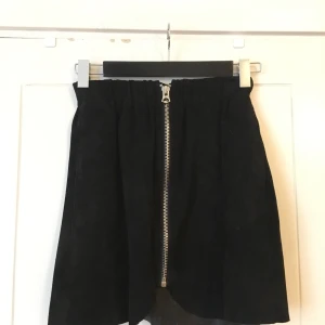 Acnekjol - Jättecool kort kjol i äkta läder från Acne. Resår i midjan och dragkedja. Den är ganska gammal men har inte använts jättemycket. Strl 36 men ganska liten i passform så funkar för 34 också! 