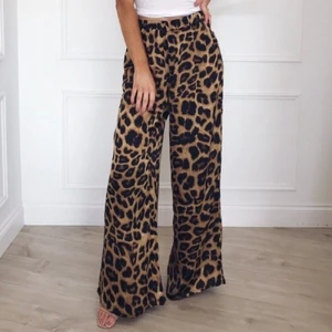Sköna Leopard Byxor - Ett par riktigt sköna byxor! Med högmidja, vidben och elastiskt. Bra tillfälle och använda när du vill sitta hemma och mysa med killen eller husdjuret! Kan också användas när du ska ut på fest med tjejgänget! Materialet är polyster vilket gör det så fruktansvärt skönt att använda!