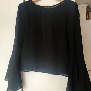 Blus med öppen rygg - Fin blus från Zara som inte kommer till användning. Öppen i ryggen med band i nacken, vida ärmar. Suuuuperbra passform! Bara lite see-through men snyggt med en svart topp under typ, eller att ha denna under en t-shirt. 