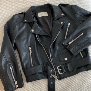 Skinnjacka från Deadwood  - Skinnjacka i återvunnet läder från Deadwood. Använd vid två fotograferingar. Finns en uppdaterad version av denna under namnet ”Joan Jacket” på deras hemsida med nypris 3500kr. Kan mötas i Stockholm eller så står köparen för frakten. 