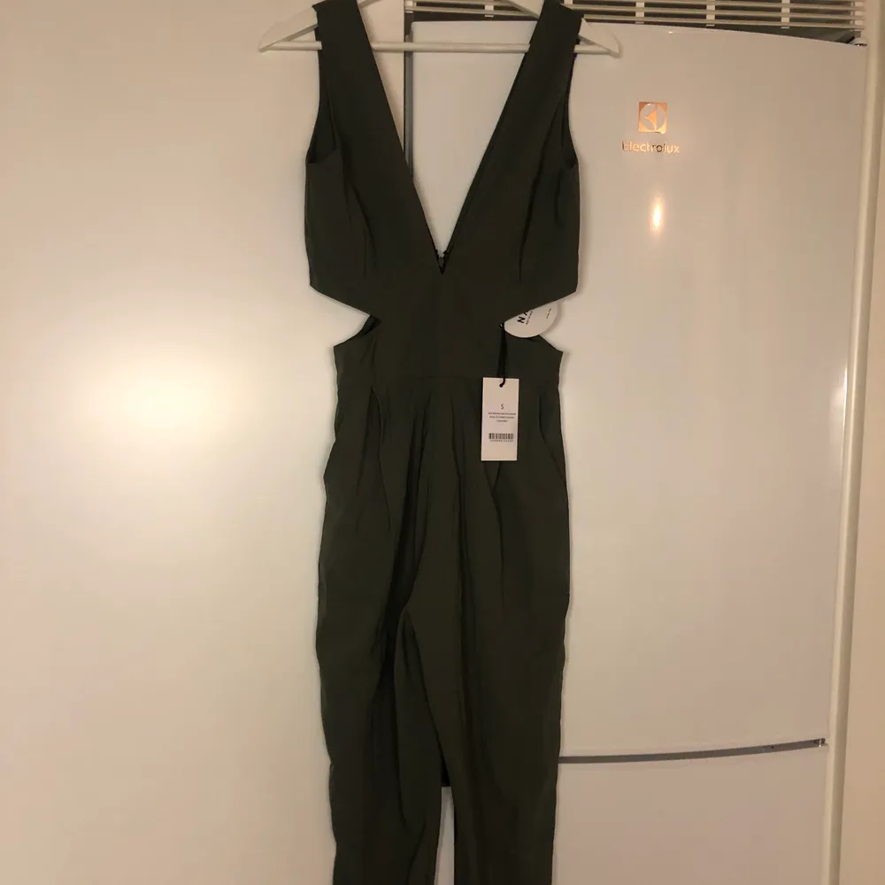 Säljer en oanvänd militärgrön jumpsuit från NAKD i storlek S. Köparen står för frakten 59kr. Klänningar.