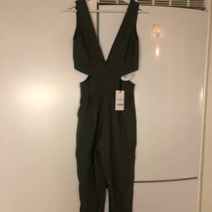 NAKD jumpsuit - Säljer en oanvänd militärgrön jumpsuit från NAKD i storlek S. Köparen står för frakten 59kr