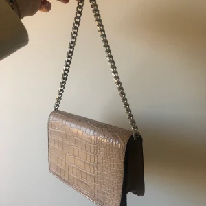 SNYGG VÄSKA - jättefin, helt oanvänd väska som bara inte kommit till användning:( den är från accent, fin beige i fake-krokodilmönster/skinn. Köpare står för frakt🥰