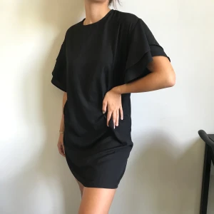 Svart klänning  - Klänning med volangärmar från Gina Tricot! Aldrig använd🥰 tar endast swish och köpare står för frakt!!💘💝🛍