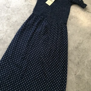En ny marinblå prickig klänning  - Aldrig använd. Med etiker på. Frakt 60kr😊