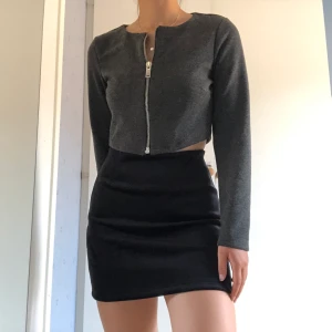 Grå kofta  - En omsydd stilren tröja som är snygg med både dragkedjan upp och ned. Passar XS-S