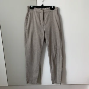 Brun beiga kostymbyxor  - Brun beiga kostymbyxor, jättebra skick och ganska nya. De är ganska korta men inte alls för korta, jag är 165 och de sitter bra på mig. I midjan är de ganska små men de är även resår, jag har oftast på mig strl.34 men dessa är inte små för mig. 