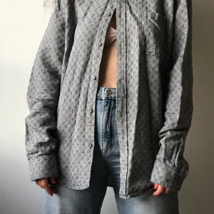 Samsøe & Samsøe skjorta - Grå skjorta från Samsøe & Samsøe. Ganska tjockt och mjukt material. Storlek står inte men sitter fint lite oversized på mig som är S/36. 100% bomull. 