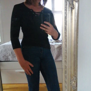 Svart ribbad tröja, knytning i halsen XS - Svart ribbad basic tröja med knytning i halsen och 3/4 ärm, storlek XS, oanvänd i nytt skick 